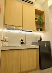 una cucina con frigorifero nero e armadietti in legno di Mahkota Superb View Apartment near A’Famosa & Jonker a Malacca