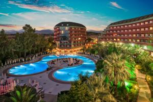 ein Hotel mit einem Pool vor einem Gebäude in der Unterkunft Delphin Deluxe Resort in Okurcalar