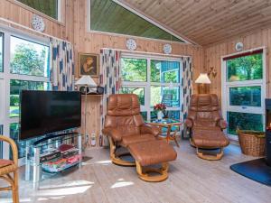 a living room with chairs and a flat screen tv at 8 person holiday home in Glesborg-By Traum in Glesborg