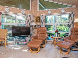 a living room with chairs and a flat screen tv at 8 person holiday home in Glesborg-By Traum in Glesborg
