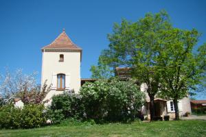 un bâtiment blanc avec une tour au-dessus d'un champ dans l'établissement Chambres d'hotes DES GRAVES, à La Celle-sous-Gouzon