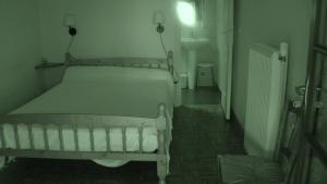 une chambre avec un lit blanc dans une pièce dans l'établissement Chambres d'hotes DES GRAVES, à La Celle-sous-Gouzon