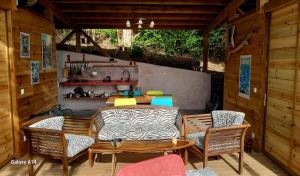 a patio with a table and chairs and a kitchen at cabane entre les arbres famille in Deshaies