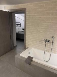 a bathroom with a bath tub and a bedroom at Kairos luxury apartments Fanari 2 in Fanárion