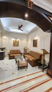 a living room with two couches and a table at Nayra Apartment by Jaiswal House in Kolkata