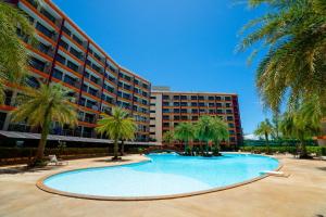 a swimming pool in front of a building with palm trees at Nature View Residence in Mai Khao Beach