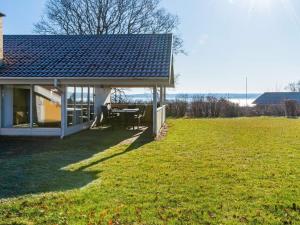 a house with a table in a field of grass at Modern Retreat by Water - By Traum Ferienwohnungen in Egeskov
