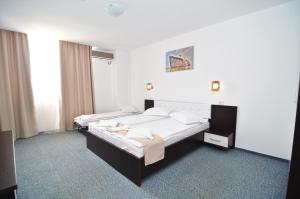 due letti in una stanza con pareti bianche di Babylonia Resort a Costinesti