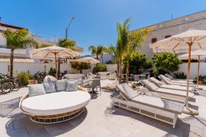 a patio with a bunch of chairs and umbrellas at Residence Medusa Luxury Suite in Porto Cesareo