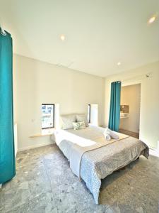 a bedroom with a large bed with blue curtains at Petit Albert in Aytré