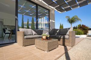 a living room with two couches on a patio at Villa Camellia - 3bed Bungalow large pool in Protaras