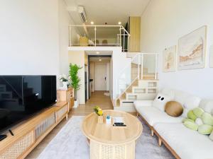 a living room with a white couch and a tv at Siamese Residence Landmark MRTA Station Bangkok in Bangkok