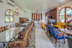 a dining room with wooden tables and chairs at บ้านสวนลุงหวัด พังงา ใกล้ท่าเรือสุระกุล in Takua Thung