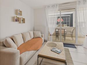 a living room with a couch and a table at Plein centre - Appart pour 6 avec balcon in La Teste-de-Buch