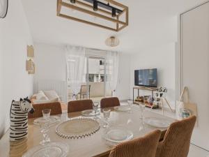 a dining room with a table and chairs at Plein centre - Appart pour 6 avec balcon in La Teste-de-Buch