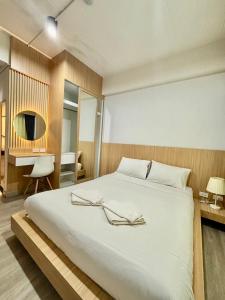 a bedroom with a large white bed and a desk at PG Ryoichi Hotel in Chiang Rai