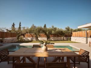 a wooden table with a vase on top of a patio at Conte Maris IV in Tragaki
