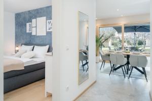 a bedroom with a bed and a dining room with a table at FENJOY Ferienapartments am Chiemsee mit Bergblick in Bernau am Chiemsee