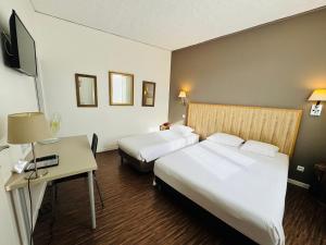 une chambre d'hôtel avec deux lits et un bureau dans l'établissement Hotel Italia, à Tours