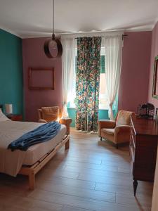 a bedroom with a bed and a chair and a window at my house intero appartamento in stazione in Pisa