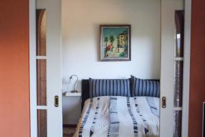 a bedroom with a bed and a picture on the wall at Casa Laluni in Porto Valtravaglia