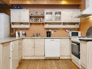 a kitchen with white cabinets and white appliances at 6 person holiday home in Fårvang-By Traum in Fårvang +16 photos