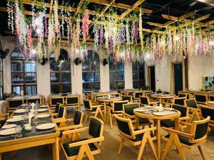 a restaurant with wooden tables and chairs and hanging flowers at Chitralekha Boutique Resort in Rājpur