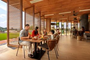 a group of people sitting at a table in a restaurant at Colugo Camp, Mandai Wildlife East in Singapore