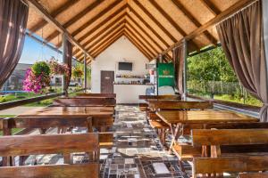 an empty restaurant with wooden tables and chairs at Fazenda Akwa Baseini in Solotvyno