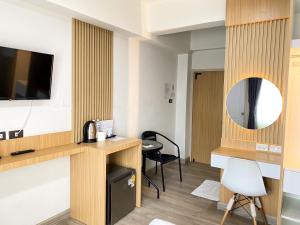a hotel room with a desk and a mirror at PG Ryoichi Hotel in Chiang Rai