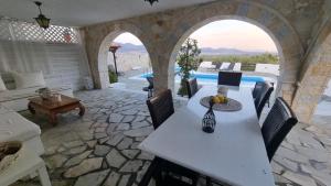 a patio with a table and chairs and a pool at Mediterranean Villa Megara in Megara