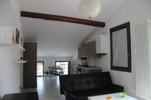 a living room with a black couch and a kitchen at B&B Villa Ermanna in Mantova