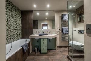 un bagno con lavandino, vasca e WC di Chalet Montanum, 9 pax - Courchevel, Bed & Breakfast a Courchevel Altre 21 foto