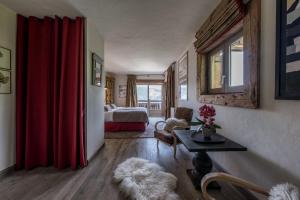 soggiorno con letto e tenda rossa di Chalet Montanum, 9 pax - Courchevel, Bed & Breakfast a Courchevel