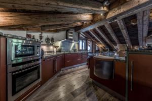 una grande cucina con pavimenti in legno e soffitti in legno di Chalet Montanum, 9 pax - Courchevel, Bed & Breakfast a Courchevel