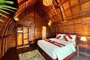 a bedroom with a bed in a wooden room at Munduk Luwih Ecolodge Bedugul by AGATA in Bedugul