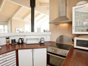 a kitchen with white cabinets and a stove top oven at 6 person holiday home in Løkken-By Traum in Løkken