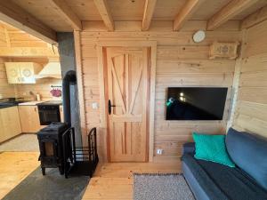 a small living room with a door and a stove at Osada na Skale Domek z kominkiem in Istebna