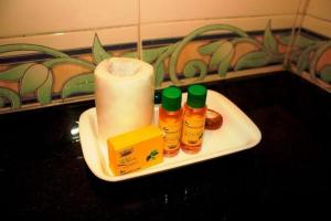 Un plato con velas y condimentos en el mostrador del baño. en hotel the lead, en Ahmedabad