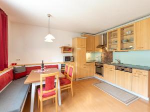 a kitchen with wooden cabinets and a table and chairs at Apartment in Strengen near Ski Slopes in Strengen