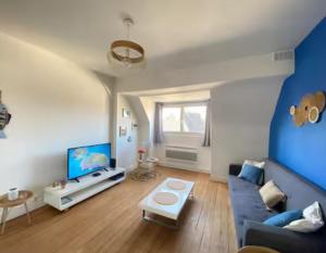 a living room with a blue couch and a tv at Le Cocon Bleu - Charmant Appartement 1 Chambre à Calais in Calais