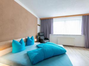 a bedroom with a blue bed with blue pillows at Apartment in Strengen near Ski Slopes in Strengen