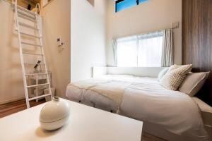 een slaapkamer met een bed en een witte vaas op een tafel bij Residence Noa 101 in Fukuoka