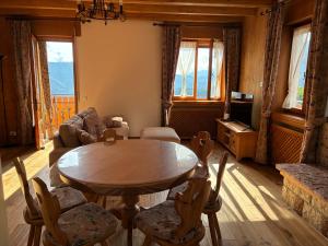 a living room with a table and chairs and a tv at Nido Altopiano in Foza