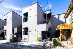 een wit gebouw met buiten geparkeerde fietsen bij Residence Noa 101 in Fukuoka