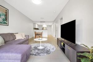 a living room with a couch and a tv at 11B Abnb-Style Charming 12 Mins Walk Train STA Free parking2BR in Bankstown