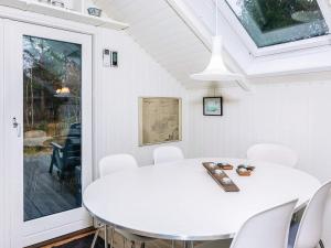 a white dining room with a white table and chairs at 6 person holiday home in Læsø in Læsø