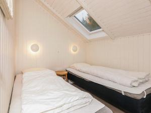 two beds in a small room with a skylight at 6 person holiday home in Læsø in Læsø +27 photos