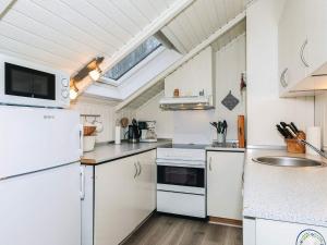 a kitchen with white appliances and a skylight at 6 person holiday home in Læsø in Læsø