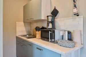 a kitchen counter with a microwave and a sink at Haus Sonnenhof Sonnenhof 10 - Joni in Kellenhusen +16 photos